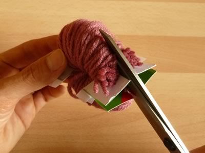 cómo hacer pompones de lana cortando